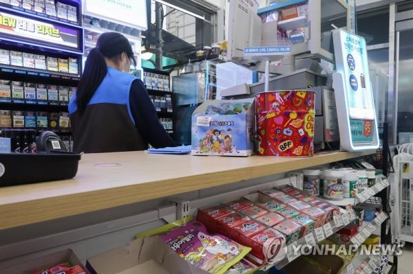 A cashier works at a co<em></em>nvenience store in Seoul, in this file photo taken Jan. 15, 2023. (Yonhap)