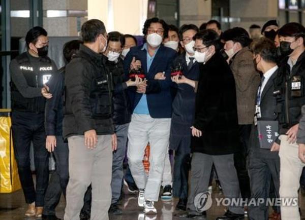 Kim Seong-tae (C), former chairman of underwear maker Ssangbangwool Group, is surrounded by prosecution investigators and reporters after arriving at Incheon Internatio<em></em>nal Airport, west of Seoul, from Thailand on Jan. 17, 2023. (Pool photo) (Yonhap)