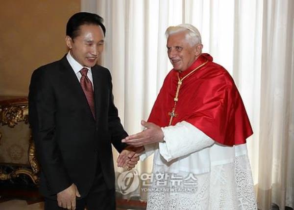 This file photo taken on July 9, 2009, shows then-South Korean President Lee Myung-bak (L) shaking hands with Pope Benedict XVI during his courtesy call on the Pope at the Vatican. (Yonhap)