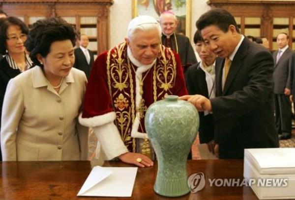 This file photo taken on Feb. 15, 2007, shows then-South Korean President Roh Moo-hyun (R) giving a piece of celadon of the Goryeo Dynasty (918-1392) to Pope Benedict XVI (C) as a gift when he visited the Vatican. (Yonhap)