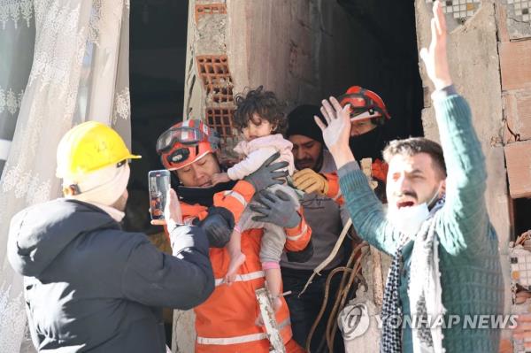 Members of a South Korean disaster relief team rescue a toddler in Antakya, the Turkish province of Hatay, on Feb. 9, 2023, after a deadly 7.8 magnitude earthquake hit Turkey and Syria on Feb. 6. (Yonhap)