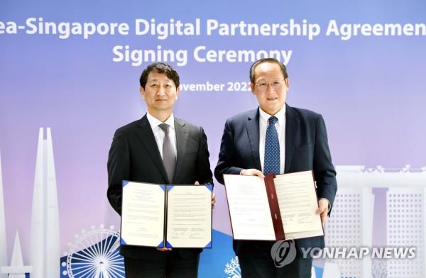 In this file photo, South Korean Trade Minister Ahn Duk-geun (L) poses with Singapore's Second Trade Minister Tan See Leng after signing a South Korea-Singapore digital partnership agreement in the island country on Nov. 21, 2022, in this photo provided by South Korea's trade ministry. (PHOTO NOT FOR SALE) (Yonhap)