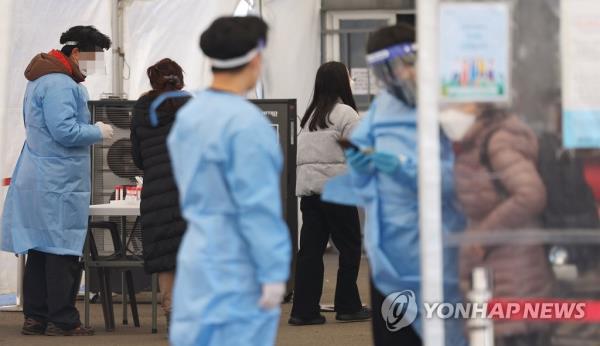 This file photo, taken Jan. 24, 2023, shows medical workers in blue protective gowns at a COVID-19 screening center in Seoul Station in central Seoul. (Yonhap)