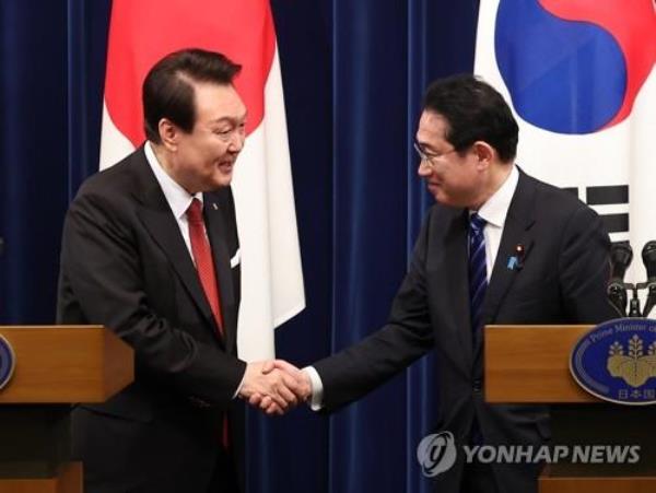 This photo shows President Yoon Suk Yeol (L) shaking hands with Japanese Prime Minister Fumio Kishida at the end of their joint news co<em></em>nference after their summit in Tokyo on March 16, 2023. (Yonhap)