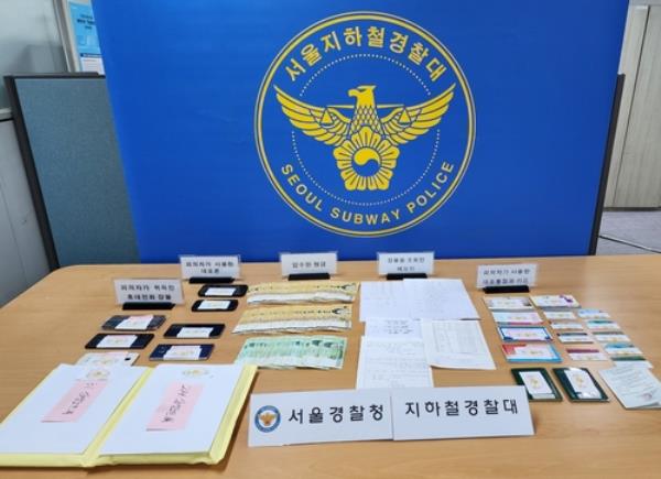 This undated photo, provided by the Seoul Subway Police, shows cash, mobile pho<em></em>nes and other objects the police seized from the leader of a phone theft ring. (PHOTO NOT FOR SALE) (Yonhap)