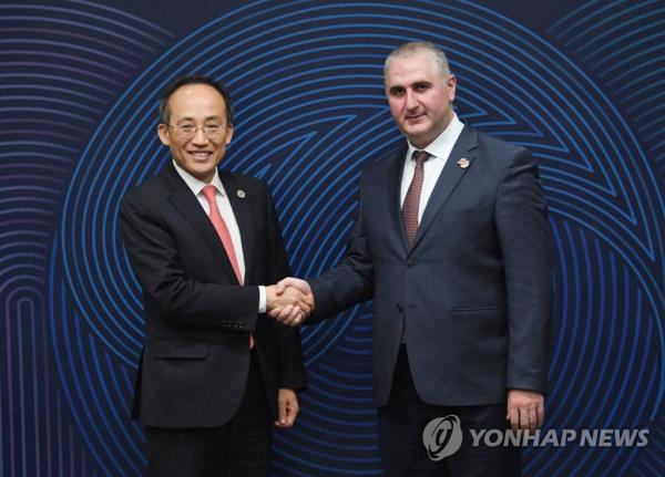 Finance Minister Choo Kyung-ho (L) shakes hands with his Georgian counterpart, Lasha Khutsishvili, at the 56th Annual Meeting of the Board of Governors of the Asian Development Bank held in Incheon, 27 kilometers west of Seoul, in this photo released by the Ministry of Eco<em></em>nomy and Finance. (PHOTO NOT FOR SALE) (Yonhap)