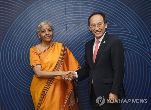 Finance Minister Choo Kyung-ho (R) shakes hands with his Indian counterpart, Nirmala Sitharaman, at the 56th Annual Meeting of the Board of Governors of the Asian Development Bank in Incheon, 27 kilometers west of Seoul, in this photo released by the Ministry of Eco<em></em>nomy and Finance. (PHOTO NOT FOR SALE) (Yonhap)