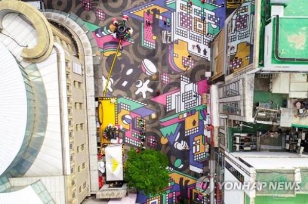 Massive street paintings are created on the main street of Myeongdong, a major tourist shopping destination in Seoul, on May 4, 2023, as part of the street's o<em></em>ngoing sales festival. (Yonhap)