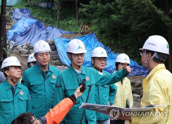 Prime Minister Han Duck-soo (C) and Seoul Mayor Oh Se-hoon (2nd from L) visit an area in Seocho Ward, Seoul, on July 23, 2023, to inspect recovery efforts from last year's landslide and preparations for a possible landslide as torrential rain has battered the country since early this month. (Yonhap)