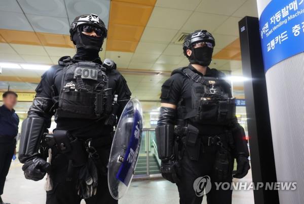 Policemen stand guard at Ori Station in Seongnam, just south of Seoul, on Aug. 4, 2023, after a man in his 20s randomly stabbed and wounded 14 people at a department store adjacent to a subway station the previous day. (Yonhap)