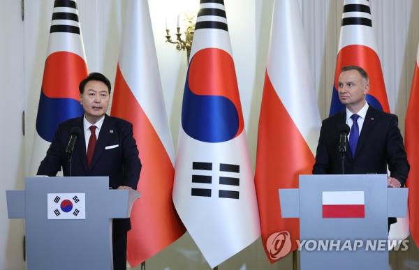 South Korean President Yoon Suk Yeol (L) and Polish President Andrzej Duda attend a joint press co<em></em>nference following their summit talks at the presidential palace in Warsaw on July 13, 2023. (Yonhap)