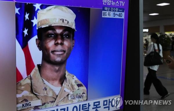 This photo, provided by AP on July 24, 2023, shows a file image of American soldier Travis King during a news program being aired at Seoul Station in central Seoul. (AP-Yonhap)