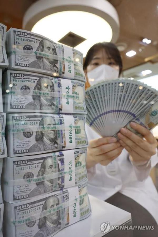 A clerk sorts US$100 banknotes at the headquarters of Hana Bank in Seoul in this file photo taken June 5, 2023. (Yonhap)