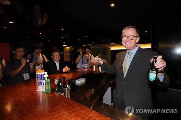 Colin Crooks (R), the British ambassador to South Korea, introduces the drinks displayed in Broughton's Club, a bar located in the office building of the British Embassy in Seoul's Jung-gu district on Sept. 11, 2023. (Yonhap)