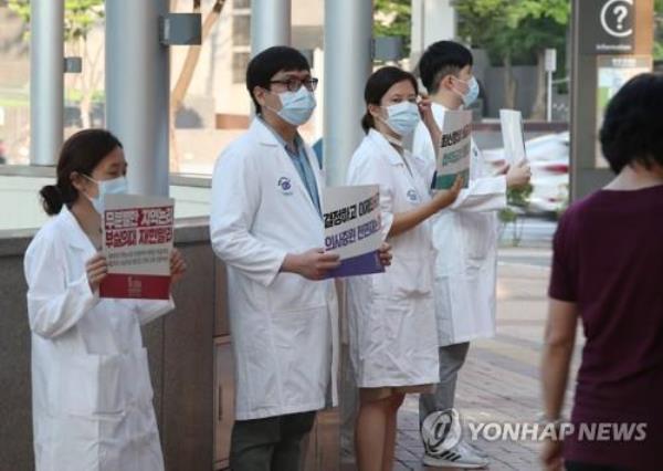 In this file photo, doctors hold up signs criticizing the government at a Seoul hospital on Aug. 26, 2020, as tens of thousands of doctors went on a full-scale strike natio<em></em>nwide for a three-day run earlier in the day in protest of the government's medical workforce reform. (Yonhap)