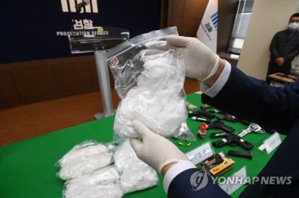 This file photo taken April 10, 2023, shows an official holding drugs seized by the prosecution during a press briefing in the prosecutors' office in Seoul. (Pool photo) (Yonhap)