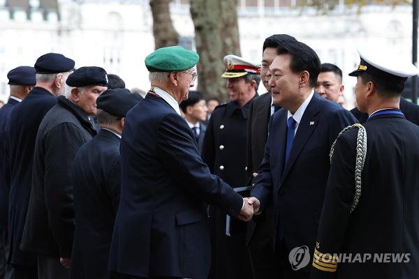 South Korean President Yoon Suk Yeol (2nd from R) meets with a group of British Korean War veterans during a visit to the Korean War Memorial in Lo<em></em>ndon on Nov. 21, 2023, to pay tribute to fallen British service members from the three-year war. Yoon arrived in the British capital the previous day for a four-day state visit to celebrate 140 years of diplomatic relations. (Yonhap)