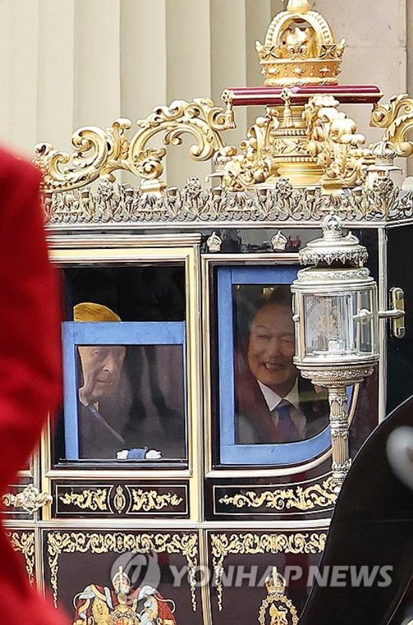 South Korean President Yoon Suk Yeol (R), accompanied by King Charles III, rides in a horse-drawn carriage en route to Buckingham Palace after attending a welcome ceremony for the South Korean leader at Horse Guards Parade in Lo<em></em>ndon on Nov. 21, 2023, during his state visit to Britain to celebrate 140 years of diplomatic relations. (Yonhap)