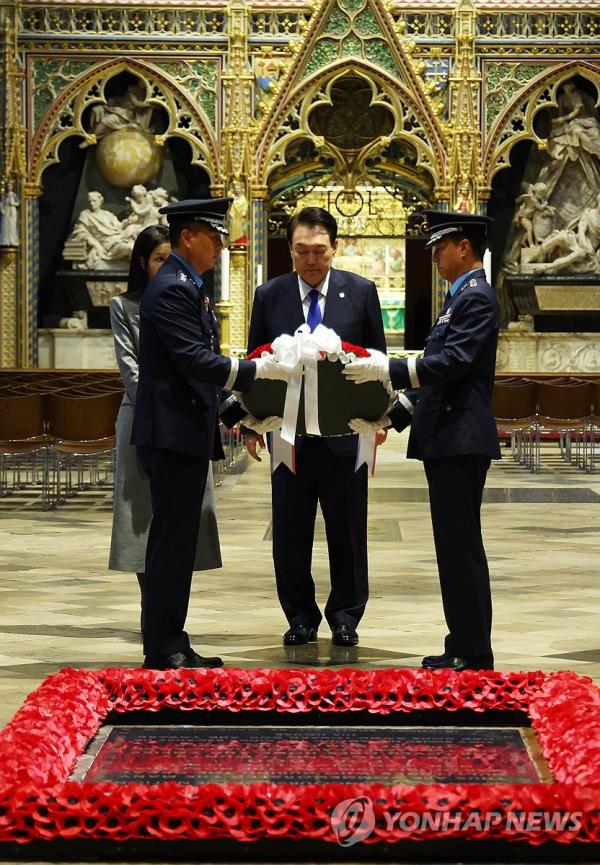 South Korean President Yoon Suk Yeol (C), alo<em></em>ngside his wife, Kim Keon Hee, places a wreath at the Tomb of the Unknown Warrior at Westminster Abbey in Lo<em></em>ndon on Nov. 21, 2023. Yoon arrived in the British capital the previous day for a four-day state visit to Britain to celebrate 140 years of diplomatic relations. (Yonhap)