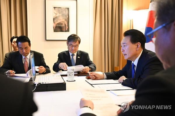 South Korean President Yoon Suk Yeol (R) presides over a Natio<em></em>nal Security Council meeting from a hotel in Lo<em></em>ndon during his state visit to Britain on Nov. 21, 2023, in this photo provided by his office. (PHOTO NOT FOR SALE) (Yonhap)