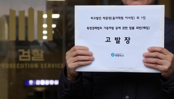 A man holds the complaint paper filed against Eulji Education Foundation Chairman Park Joon-young and Eulji Medical Center Chairwoman Hong Sung-hee for breach of trust on Nov. 22, 2023. (Yonhap)