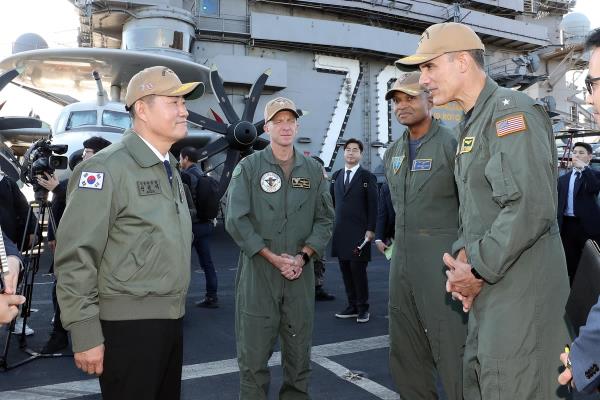 Defense Minister Shin Won-sik (L) meets Rear Adm. Carlos Sardiello, commander of carrier strike group one, (R) during his visit to the USS Carl Vinson, a nuclear-powered aircraft carrier docked in Busan, 320 kilometers southeast of Seoul, on Nov. 22, 2023, in this photo provided by the defense ministry. (PHOTO NOT FOR SALE) (Yonhap)