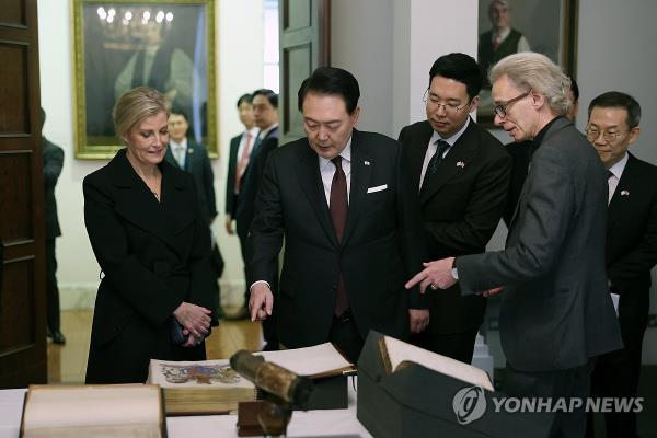 South Korean President Yoon Suk Yeol (C) looks at an exhibition at the Royal Society, Britain's natio<em></em>nal academy of sciences, in Lo<em></em>ndon on Nov. 22, 2023. (Yonhap)