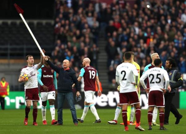 Ashley Barnes of Burnley co<em></em>nfronts a pitch invador who stole the corner flag during the Premier League match between West Ham United and Burnley at Lo<em></em>ndon Stadium